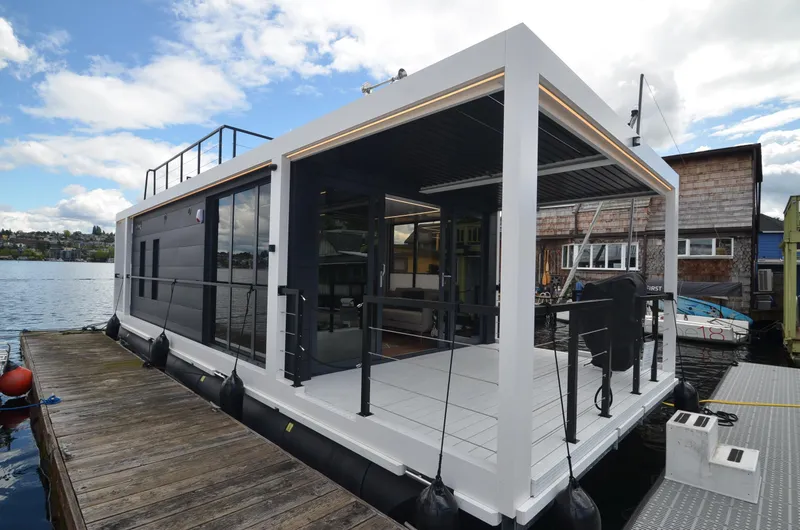 Slide: The Image of Modern 2024 La Mare houseboat, model Modern 11, docked on a serene lake. - 5