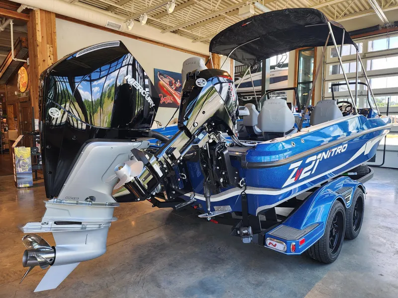 Slide: The Image of 2024 Nitro ZV21 boat in showroom, rear view with powerful outboard motor. - 2