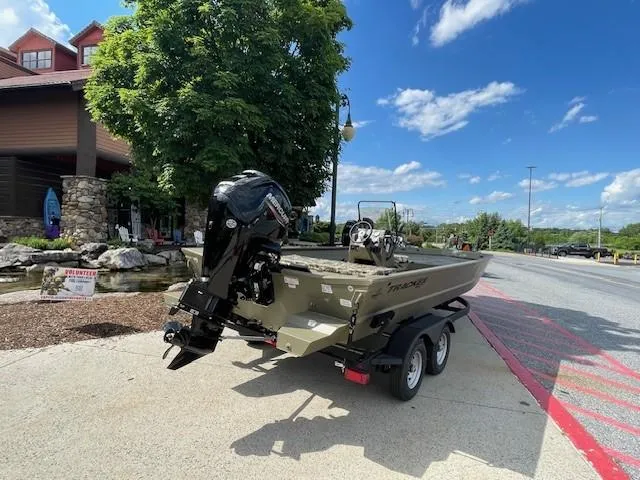 Slide: The Image of 2024 Tracker Grizzly 2072 CC boat on a trailer, parked outdoors on a sunny day. - 4