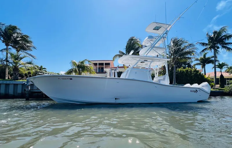 Slide: The Image of 2015 Billfish 39 Custom CC boat docked near palm trees and waterfront homes. - 0