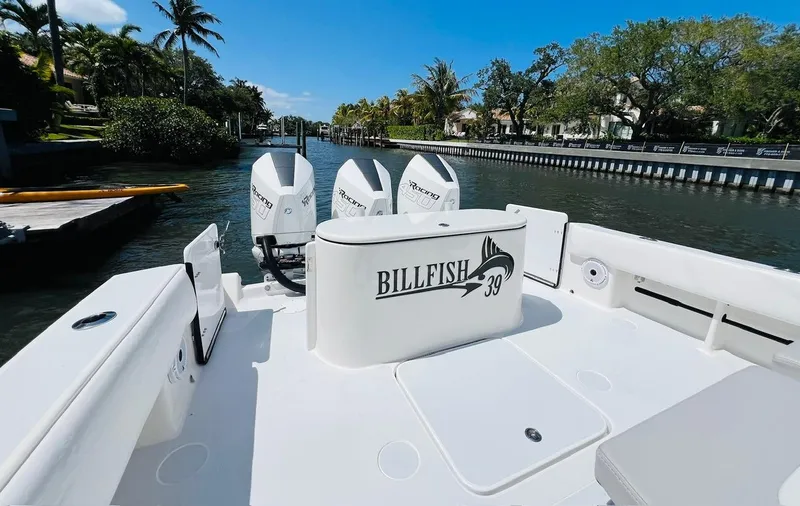 Slide: The Image of 2015 Billfish 39 Custom CC boat with triple outboard engines docked in a scenic canal. - 41