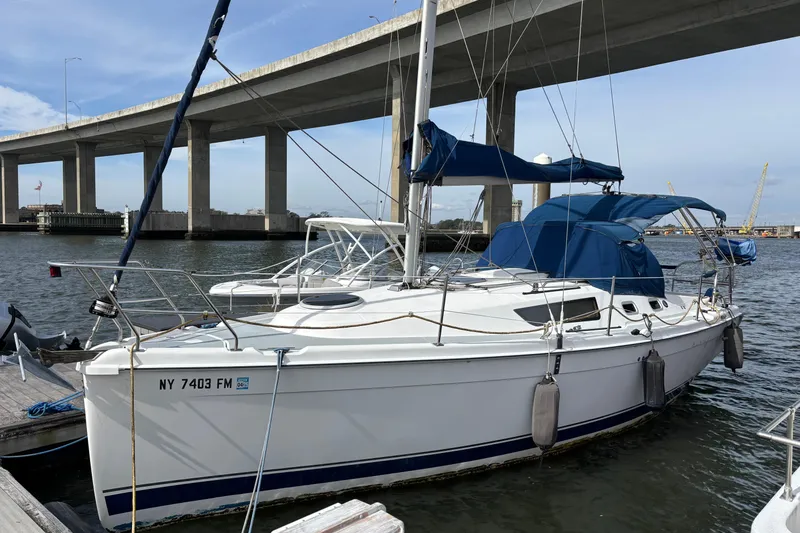 The Image of 2005 Hunter 31 sailboat docked under bridge. - 0