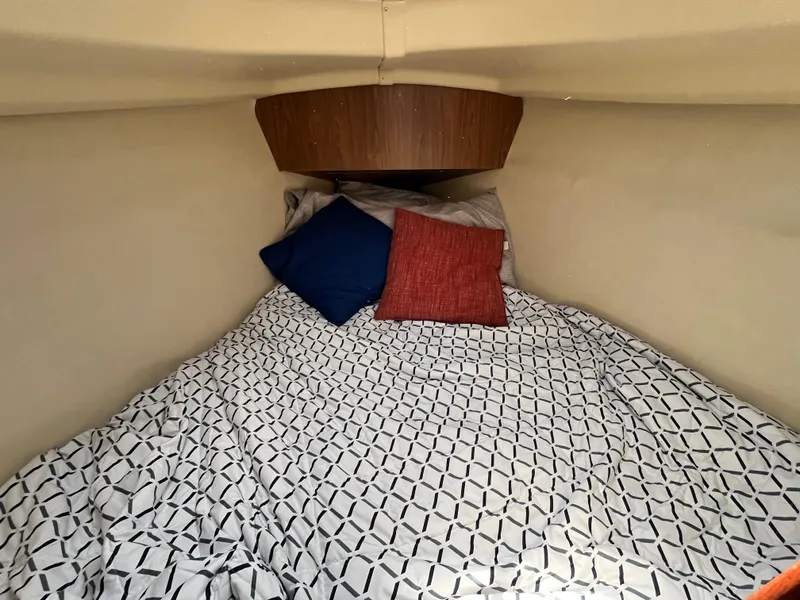 Slide: The Image of Cozy cabin interior of 2005 Hunter 31 sailboat with patterned bedding and colorful pillows. - 16