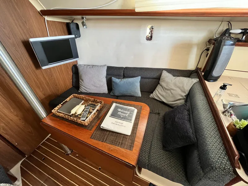 Slide: The Image of Cozy interior of 2005 Hunter 31 sailboat with seating, cushions, and a mounted TV. - 17
