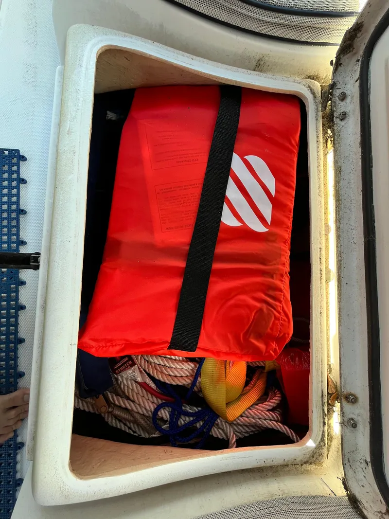 Slide: The Image of Storage compartment on a 2005 Hunter 31 sailboat with life jacket and ropes. - 8