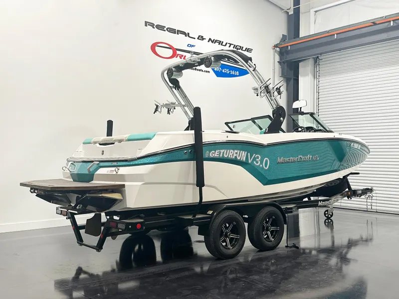 Slide: The Image of 2020 MasterCraft NXT 22 boat on trailer in showroom. - 2