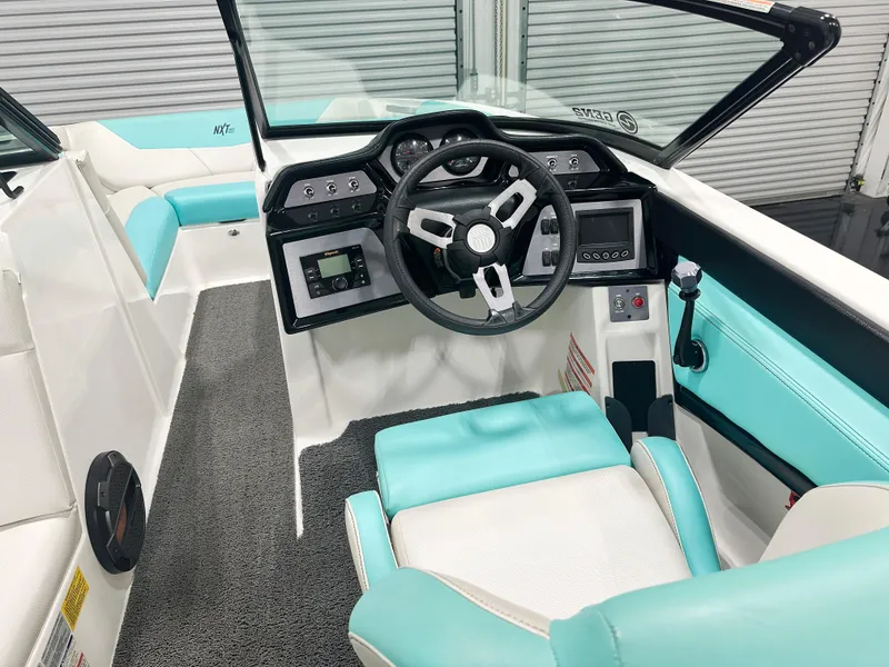 Slide: The Image of 2020 MasterCraft NXT 22 boat interior with turquoise and white seating, modern dashboard, and steering wheel. - 7