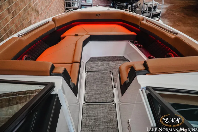 Slide: The Image of 2023 Cobalt R8 boat interior with brown seating and red ambient lighting at Lake Norman Marina. - 14