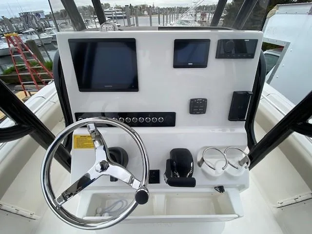 Slide: The Image of 2024 Key West 219 FS boat dashboard with steering wheel, navigation screens, and controls. - 6