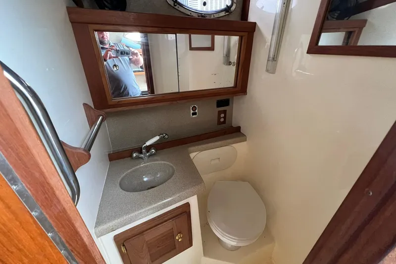 Slide: The Image of 2002 Albemarle 285 Express Fisherman boat bathroom with sink, mirror, and toilet. - 16