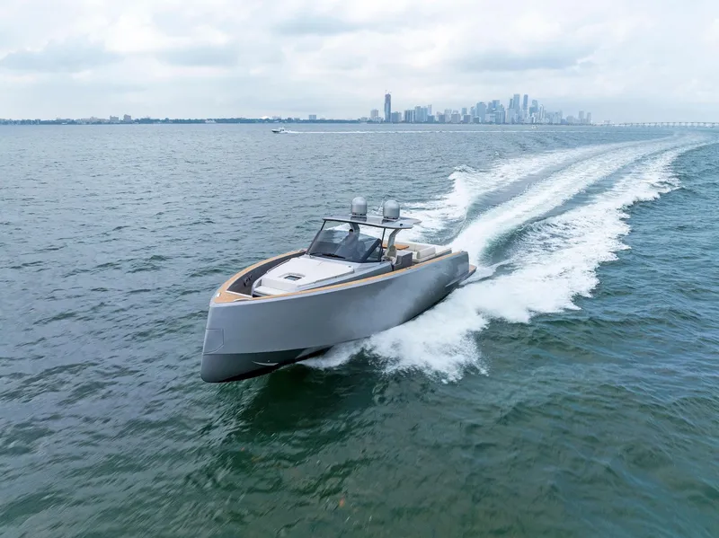 Slide: The Image of 2023 Pardo Yachts 50 cruising on open water with city skyline in the background. - 18