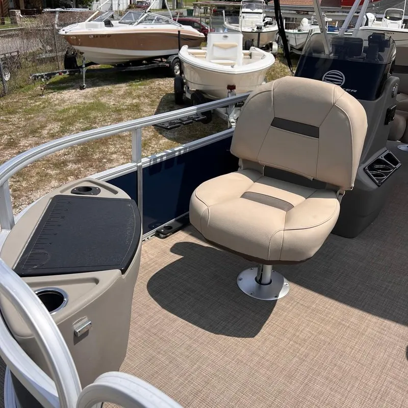 Slide: The Image of 2023 Sun Tracker Party Barge 18 DLX interior with beige captain's chair and console. - 10