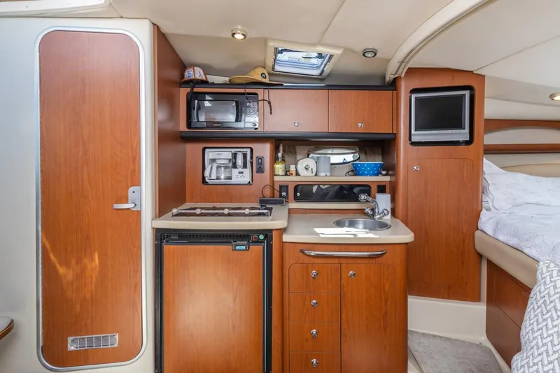 Slide: The Image of 2004 Chaparral Signature 310 boat interior kitchen with microwave, stove, and TV. - 22