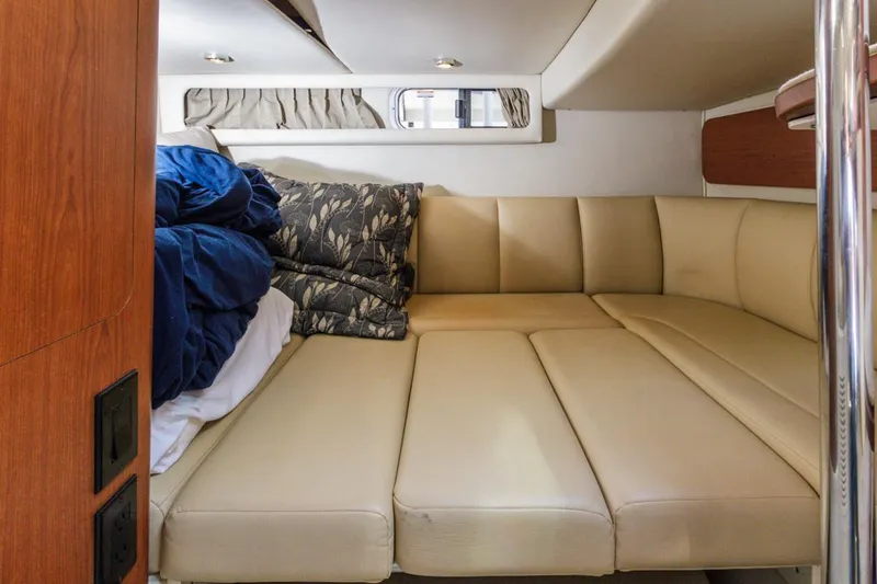 Slide: The Image of 2004 Chaparral Signature 310 cabin with beige leather seating and bedding. - 24