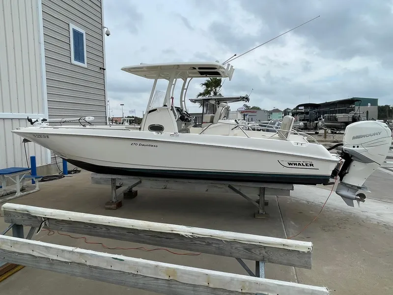 The Image of 2017 Boston Whaler 270 Dauntless boat on a dock, overcast sky background. - 0