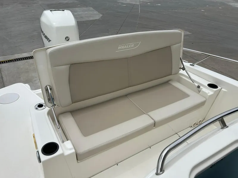 Slide: The Image of 2017 Boston Whaler 270 Dauntless boat seating area with beige cushions and cup holders. - 24