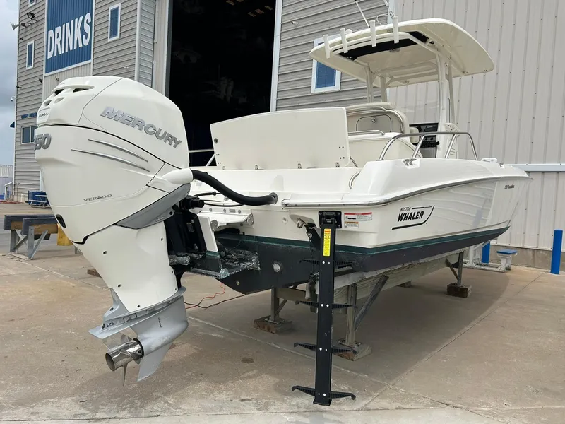 Slide: The Image of 2017 Boston Whaler 270 Dauntless boat with Mercury engine, docked near a building. - 3