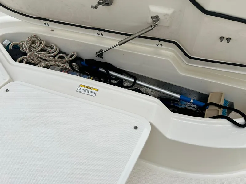 Slide: The Image of Open storage compartment on a 2017 Boston Whaler 270 Dauntless boat with ropes and equipment. - 33
