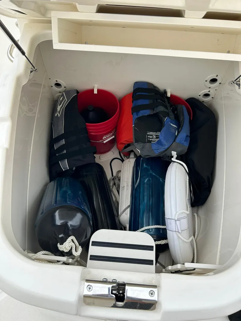 Slide: The Image of Storage compartment on a 2017 Boston Whaler 270 Dauntless, filled with boating gear and accessories. - 41