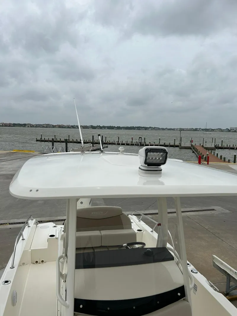 Slide: The Image of 2017 Boston Whaler 270 Dauntless boat docked by a cloudy waterfront. - 49