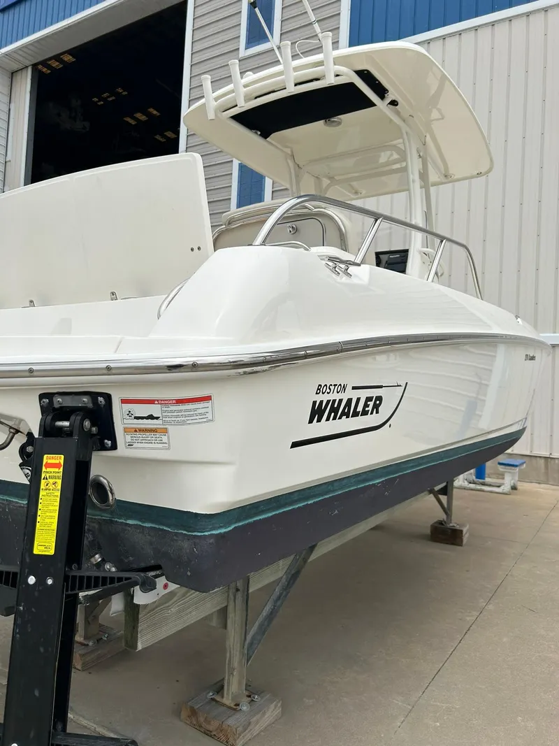 Slide: The Image of 2017 Boston Whaler 270 Dauntless boat on trailer, parked outside a building. - 9