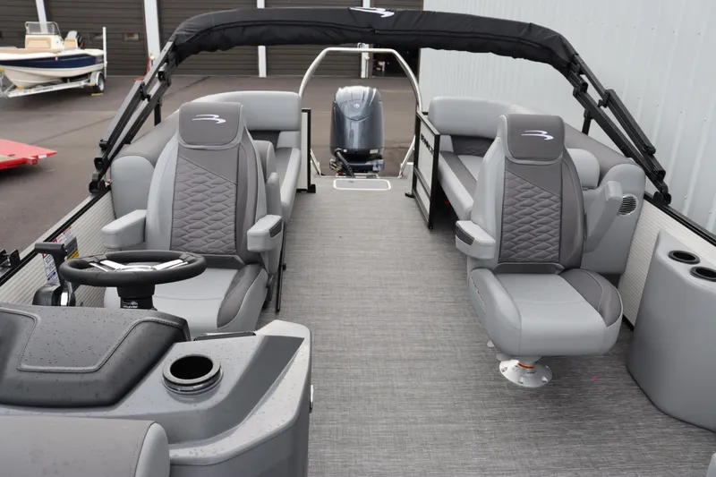 Slide: The Image of 2024 Bennington 22 SSR-SPS pontoon boat interior with gray seating and steering console. - 9