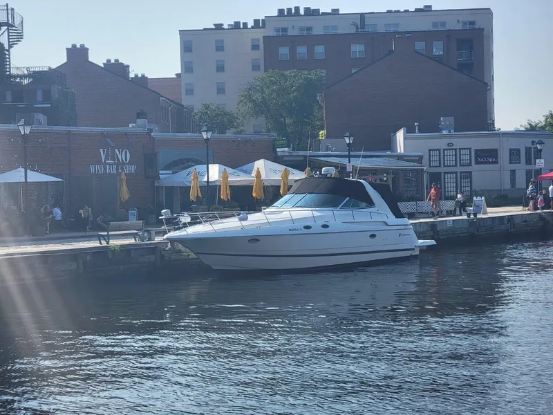 Slide: The Image of 2000 Cruisers 3870 Express yacht docked by waterfront buildings. - 22