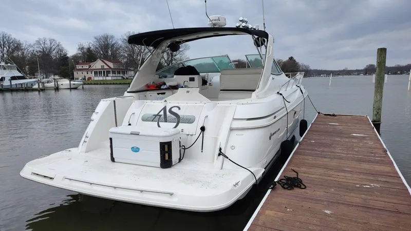 Slide: The Image of 2000 Cruisers 3870 Express boat docked on a calm lake. - 5