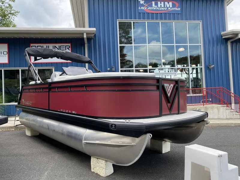 Slide: The Image of 2024 Viaggio Lago V-18U Bi-Toon pontoon boat displayed outside a marine dealership. - 2