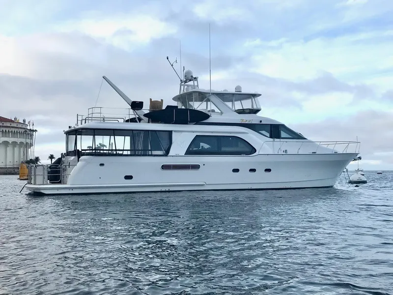 The Image of 1999 Queenship Cockpit Motoryacht on calm waters with a scenic backdrop. - 0