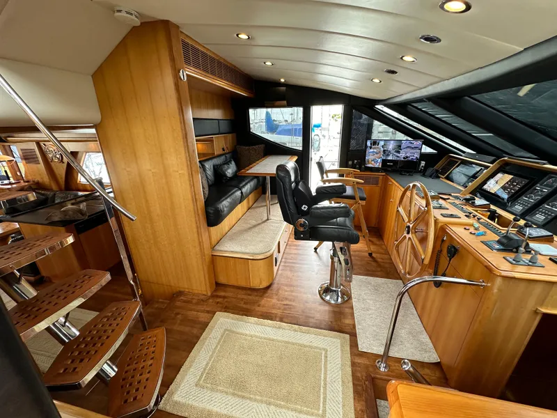 Slide: The Image of 1999 Queenship Cockpit Motoryacht interior with helm station, seating, and wooden finishes. - 12