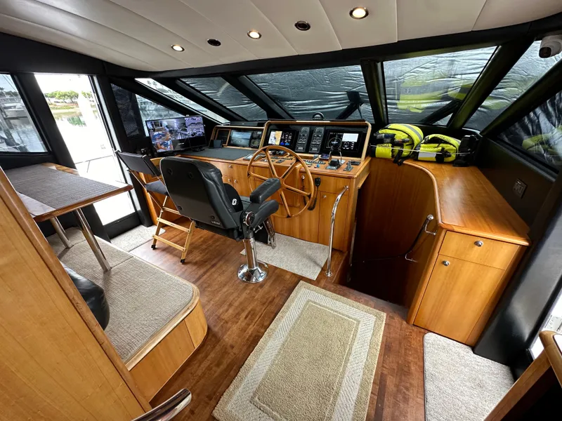 Slide: The Image of 1999 Queenship Cockpit Motoryacht interior with helm station and seating area. - 13