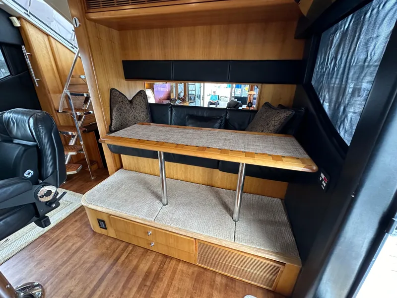 Slide: The Image of 1999 Queenship Cockpit Motoryacht interior with seating area and wooden table. - 14