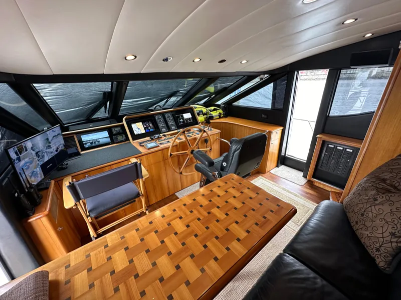 Slide: The Image of 1999 Queenship Cockpit Motoryacht helm station with modern navigation equipment and luxurious wood finishes. - 15