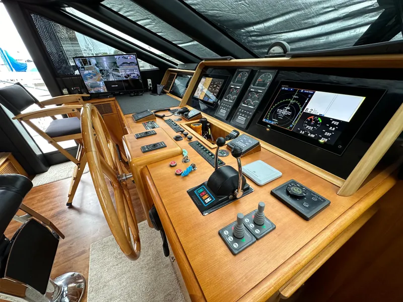 Slide: The Image of 1999 Queenship Cockpit Motoryacht helm with navigation controls and wooden steering wheel. - 17