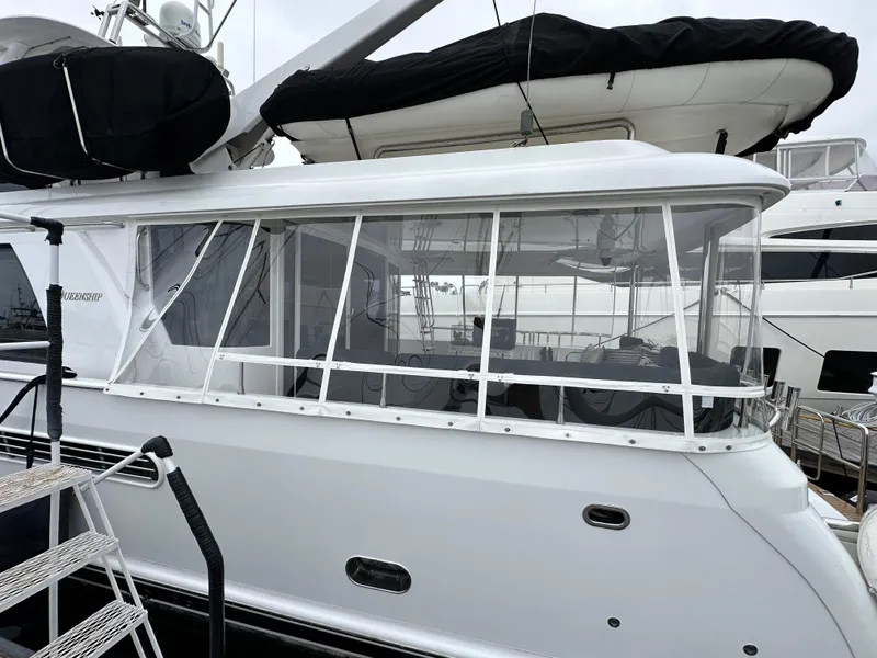 Slide: The Image of 1999 Queenship Cockpit Motoryacht with enclosed cockpit, docked at marina. - 2