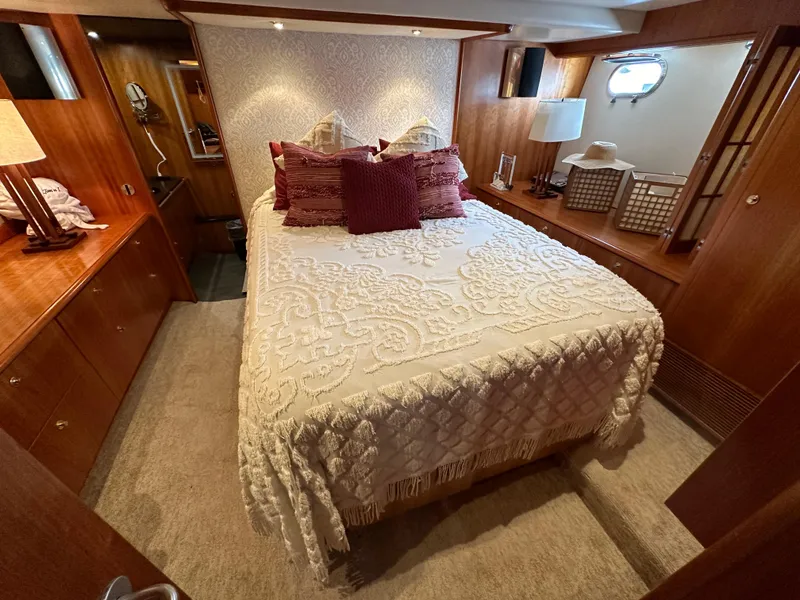Slide: The Image of Luxurious bedroom in a 1999 Queenship Cockpit Motoryacht with elegant bedding and wooden decor. - 21