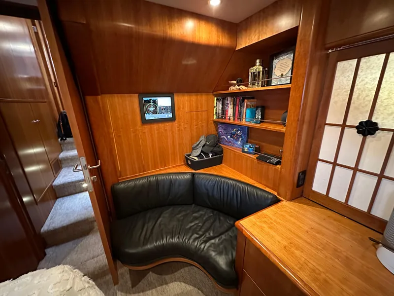 Slide: The Image of 1999 Queenship Cockpit Motoryacht interior with leather seating, wooden shelves, and cozy decor. - 26