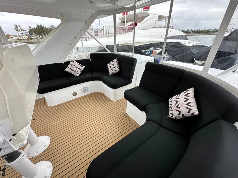 Slide: The Image of 1999 Queenship Cockpit Motoryacht interior with black seating and patterned cushions. - 37