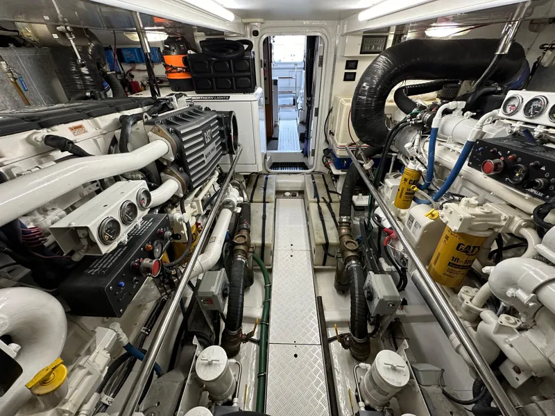Slide: The Image of Engine room of a 1999 Queenship Cockpit Motoryacht with visible machinery and equipment. - 41