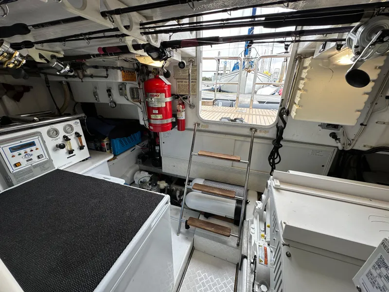 Slide: The Image of Engine room of a 1999 Queenship Cockpit Motoryacht with control panels and fire extinguisher. - 45