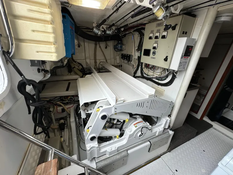 Slide: The Image of Engine room of a 1999 Queenship Cockpit Motoryacht with visible machinery and control panels. - 46
