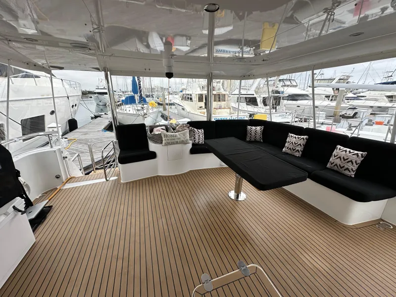 Slide: The Image of 1999 Queenship Cockpit Motoryacht with spacious seating area and marina view. - 5