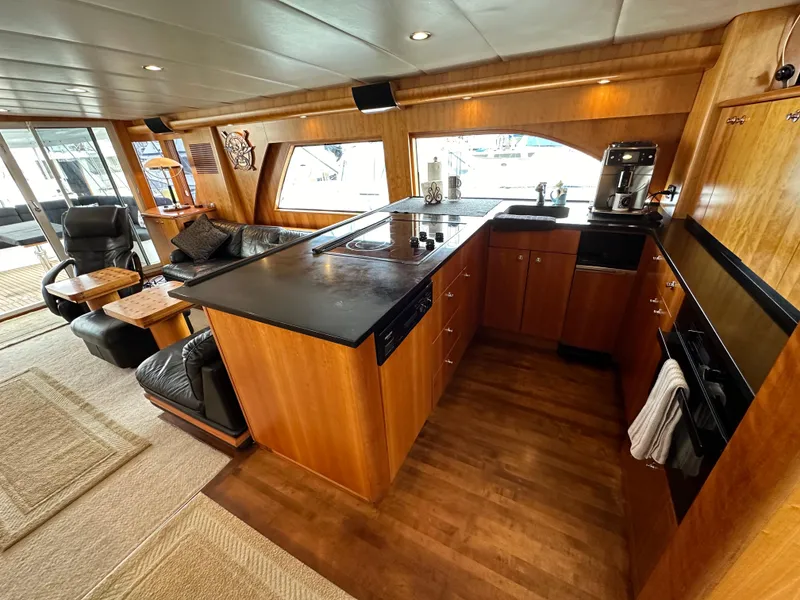 Slide: The Image of Luxurious interior of 1999 Queenship Cockpit Motoryacht with modern kitchen and comfortable seating. - 9