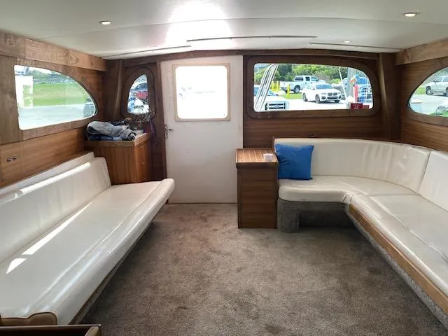 Slide: The Image of Interior of 2022 Custom Carolina Sportfish boat with white seating and wood accents. - 10