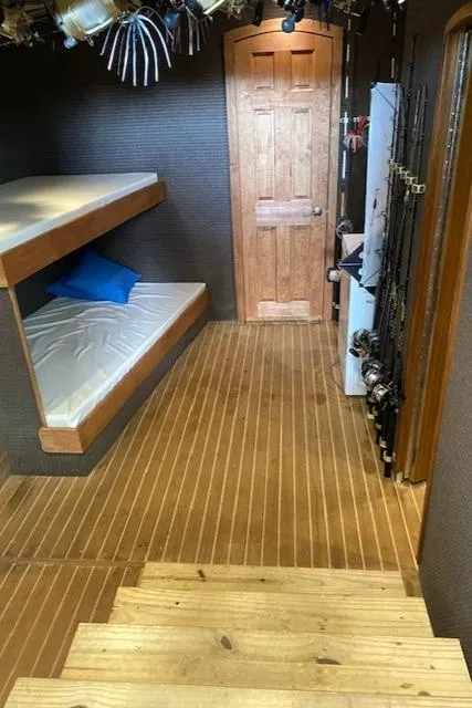 Slide: The Image of Interior of 2022 Custom Carolina Sportfish with wooden flooring, bunk beds, and fishing rods. - 11