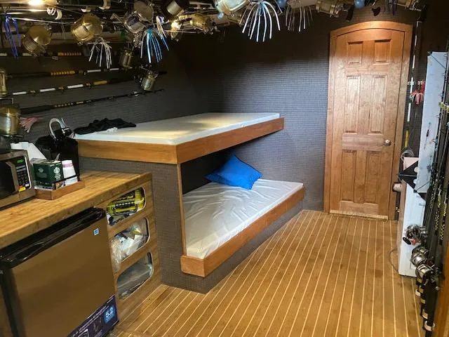 Slide: The Image of 2022 Custom Carolina Sportfish interior with bunk beds and fishing gear. - 12