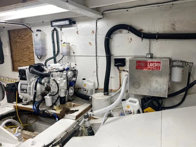 Slide: The Image of Engine room of a 2022 Custom Carolina Sportfish boat with various equipment and containers. - 27