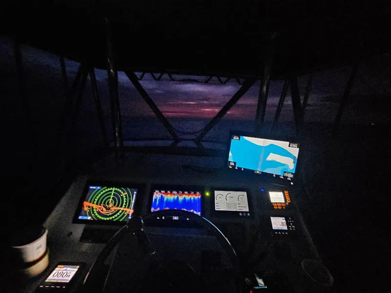 Slide: The Image of Cockpit view of 2022 Custom Carolina Sportfish at night with navigation screens. - 30