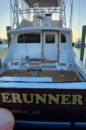 Slide: The Image of 2022 Custom Carolina Sportfish boat docked, rear view with fishing chairs and equipment. - 38